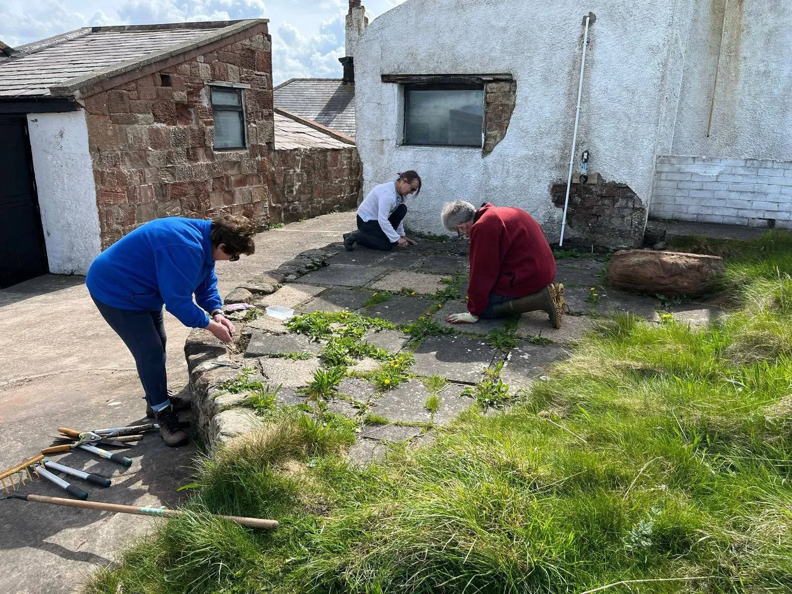 Volunteers carrying out practical maintenance beside an island building
