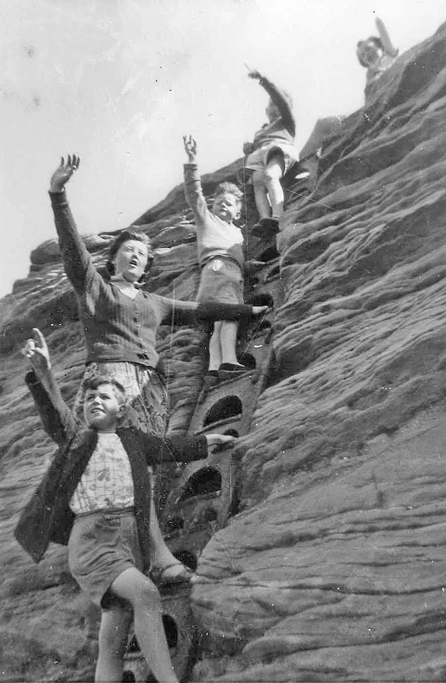 An historic photograph of people climbing on the island rocks