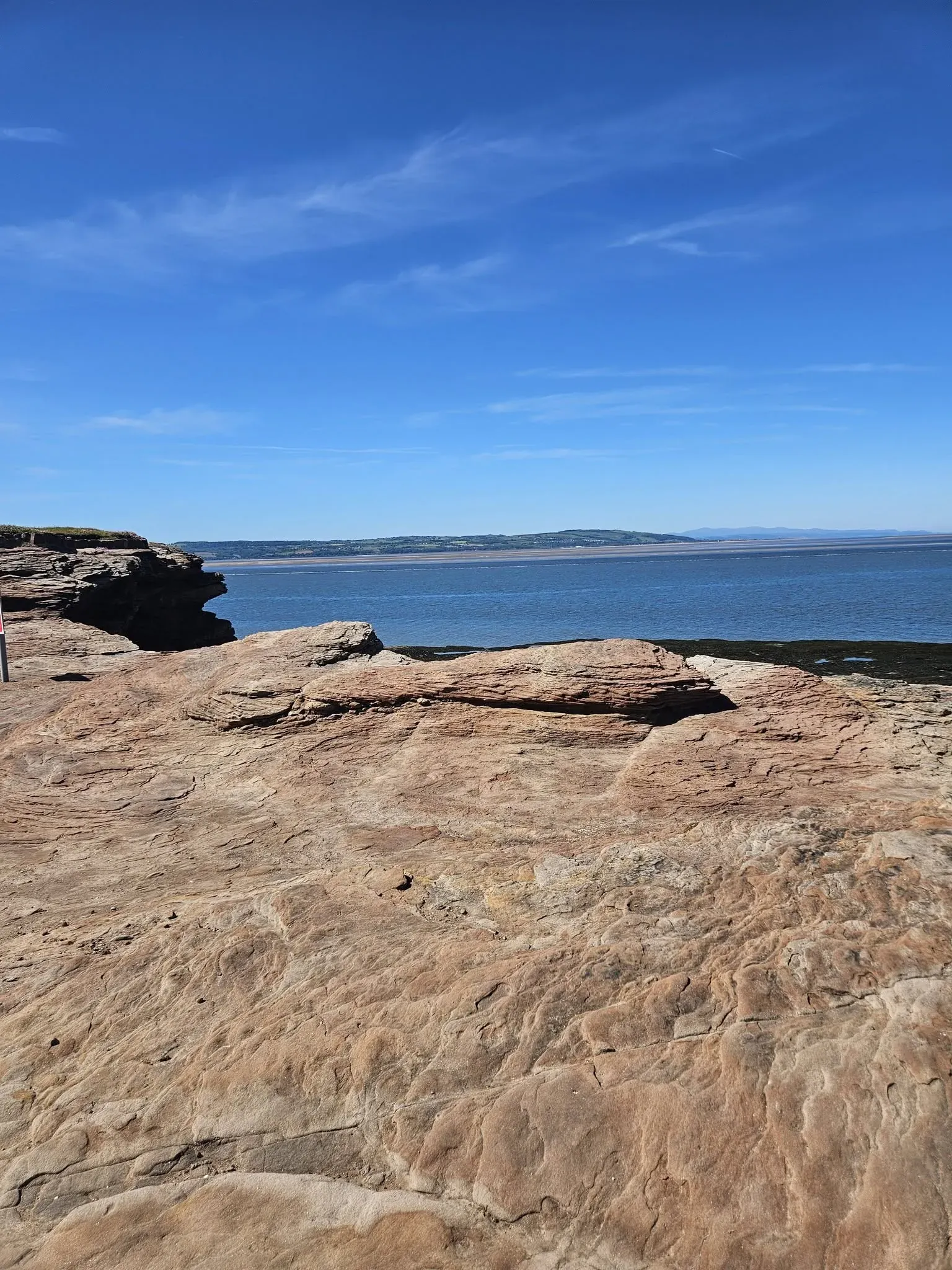 The broad sandstone and rocky foreshore on the island