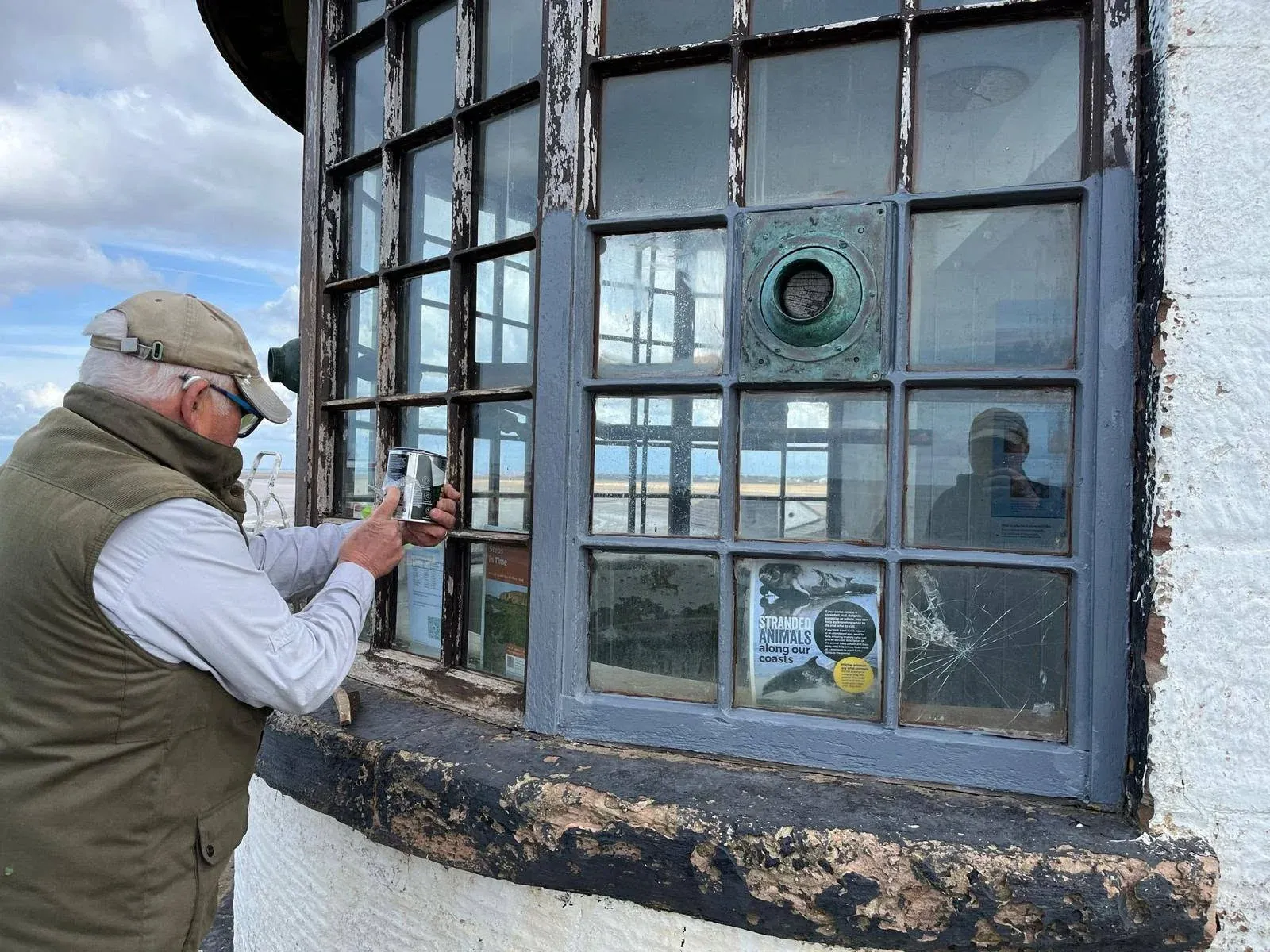 A volunteer carrying out maintenance on the Telegraph Station windows